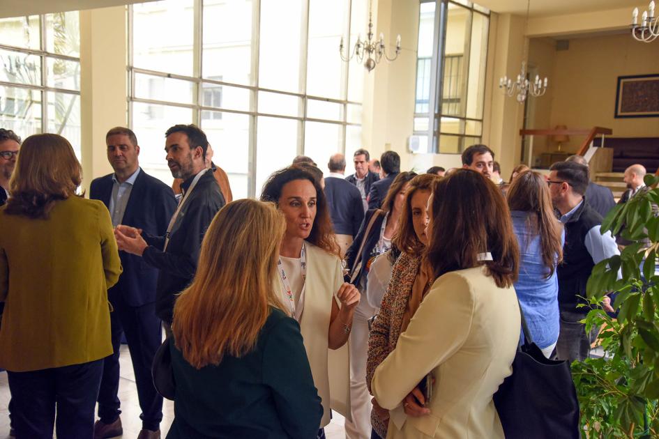 Personas dialogan en un espacio con grandes ventanas