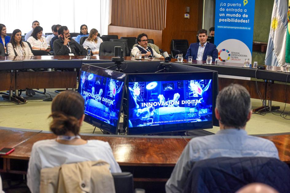 La tercera edición de Innovation Forum se desarrolló en la sede de ALADI Público sentado en una mesa circular; en el medio se ven pantallas que forman un prisma