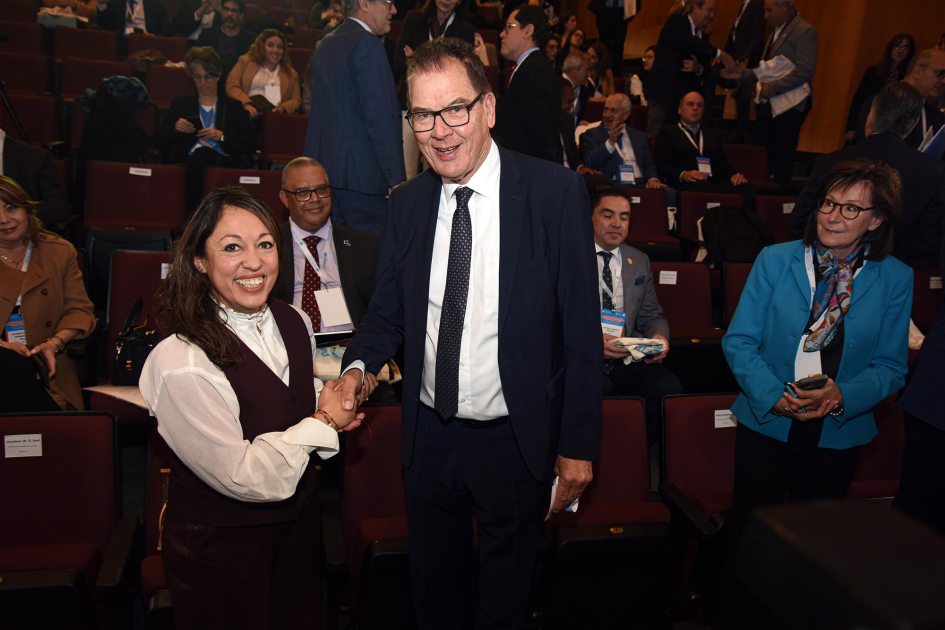 Ministra Fernanda Cardona y director general de la ONUDI, Gerd Müller Cardona y Müller se dan la mano; detrás, público