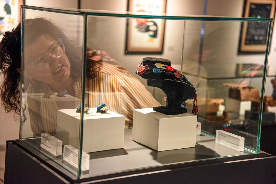 Artesanías premiadas Una mujer ve artesanías (joyería) en una caja de vidrio