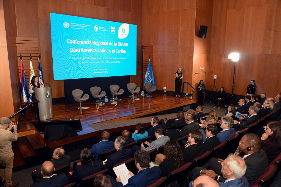 Sesión inaugural de la Conferencia Regional de la ONUDI para América Latina y el Caribe Al fondo, escenario en el que habla la ministra Cardona y pantalla; más cerca, público, de espaldas