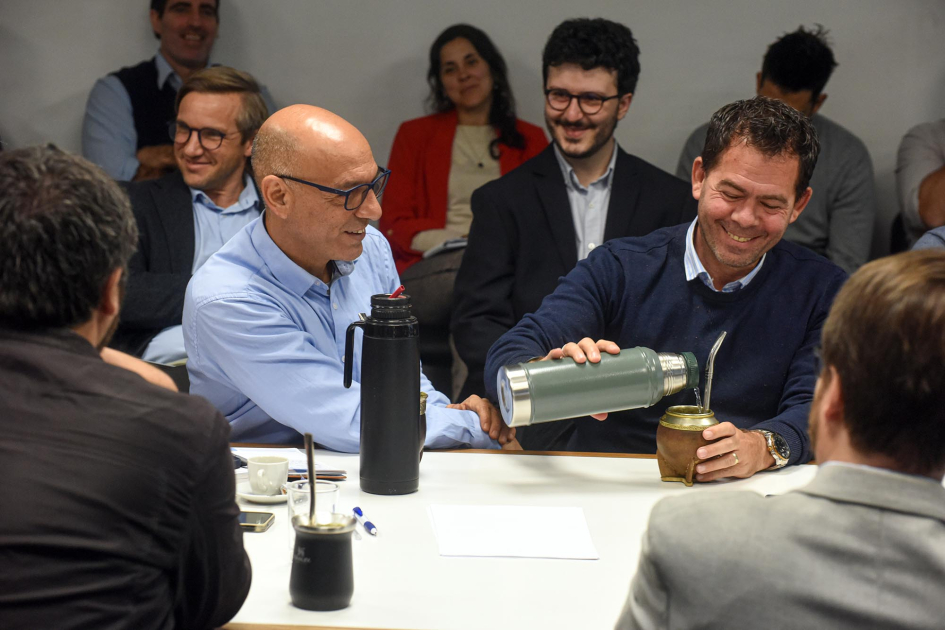 Marcelo Abdala y Leonardo García, presidentes del PIT-CNT y de la CIU, respectivamente, participaron Abdala y García sonríen, mientras este ceba mate, en una mesa con otras personas