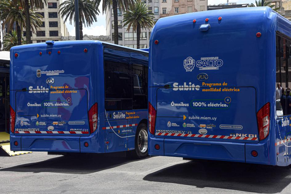 Subite Buses se enmarca en el programa de promoción de la electromovilidad Subite, también del MIEM Dorso de dos ómnibus; son azules y tienen destacado el logo del programa Subite