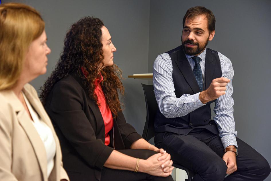 Director de la DNPI, Santiago Martínez Director Martínez habla mirando a Sauksteliskis y Varela; están sentados en banquetas
