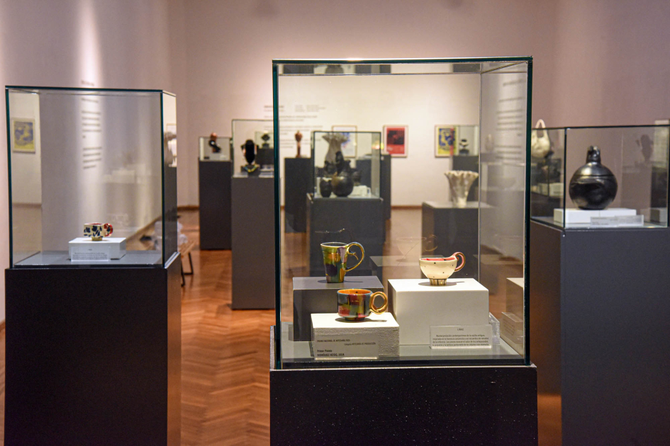 Exhibición del Premio Nacional de Artesanía 2025 Piezas en cajas de vidrio; detrás, personas