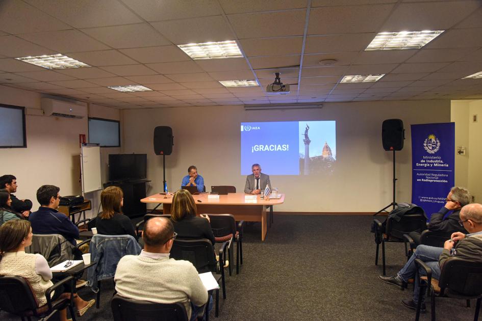 Reunión de expertos con la ARNR Auditorio y autoridades en una sala; al fondo, una pantalla