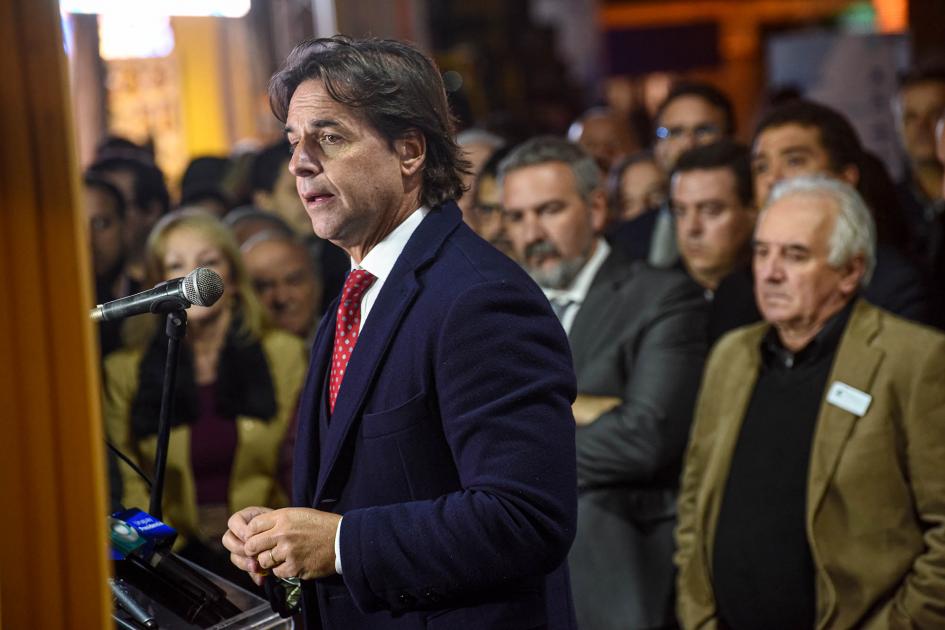 El presidente Luis Lacalle Pou expuso en la inauguración Luis Lacalle Pou habla con varias personas detrás