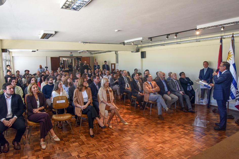 El director Marcelo Pugliesi ofreció una perspectiva sobre Dinamige y la actividad minera Director Pugliesi habla ante el público, que se ve de frente; detrás, pabellones
