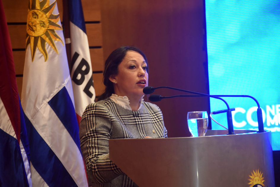 La ministra Fernanda Cardona expuso en la apertura del evento Cardona habla desde un atril; a su lado, banderas
