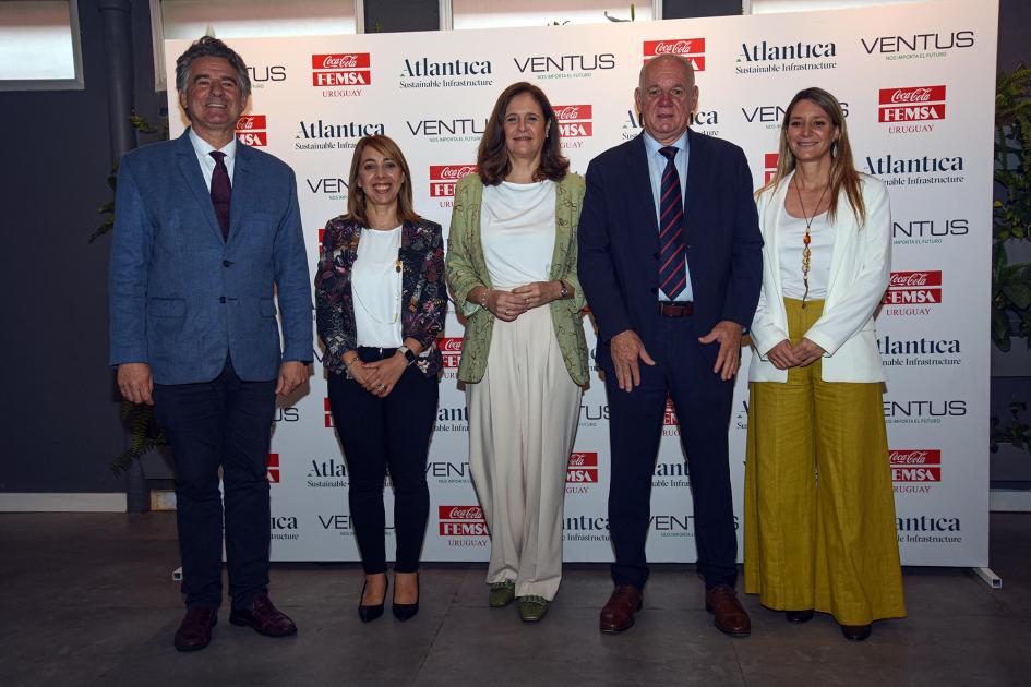 Autoridades y representantes de Coca-Cola Femsa Uruguay Facio, Verri, Amarilla y dos mujeres, gerentas de Coca-Cola Femsa; detrás hay un banner
