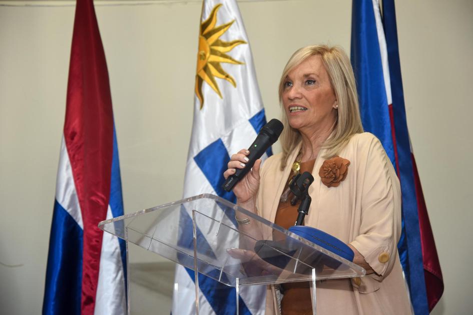 Vicepresidenta Beatriz Argimón Vicepresidenta Argimón habla desde un atril; detrás, pabellones patrios
