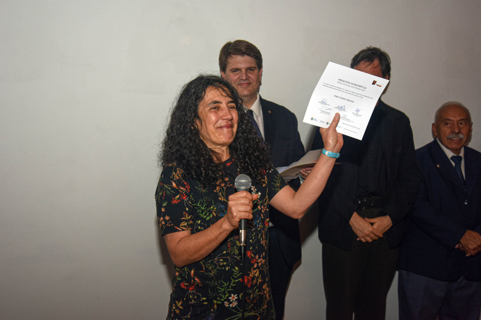 Inés Castro (mención en Pieza única) Artesana sostiene diploma; detrás, autoridades