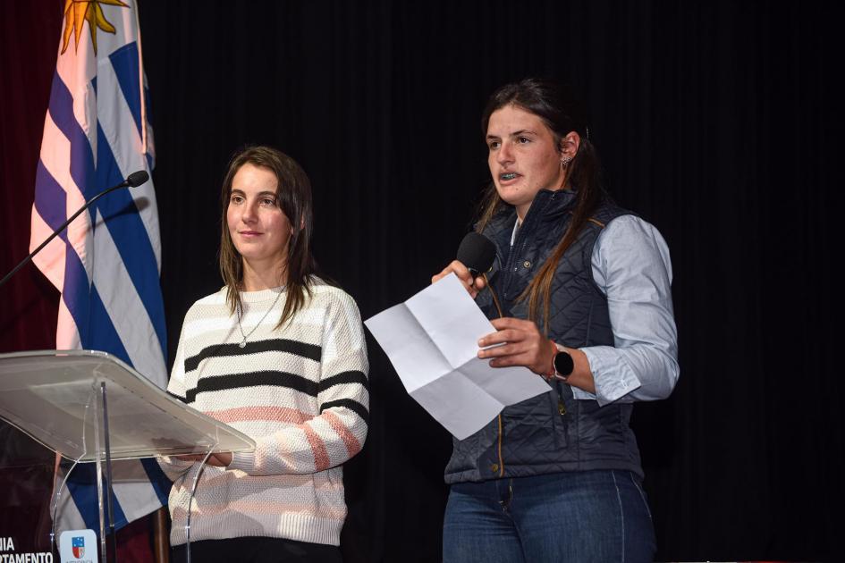 Dos jóvenes emprendedoras; al lado, la bandera uruguaya