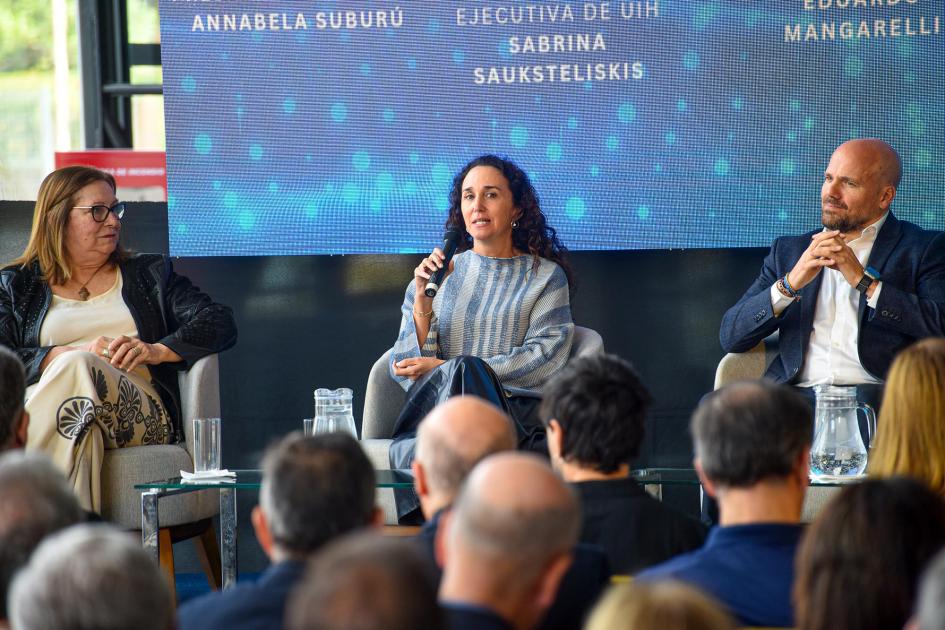 Directora ejecutiva de Uruguay Innovation Hub, Sabrina Sauksteliskis Sauksteliskis habla en el segundo panel del evento; a su lado, panelistas; enfrente, público