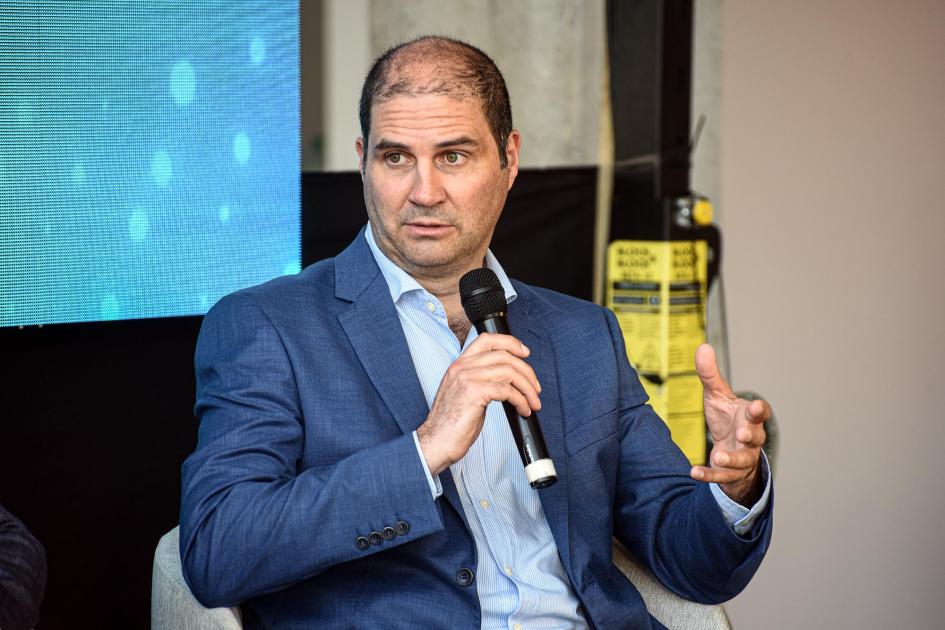 Presidente de ANII, Flavio Caiafa Caiafa habla con un micrófono; detrás, pantalla