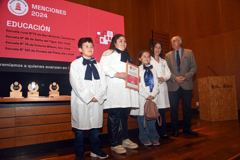 Mención: Escuela rural n.° 74 de San Antonio, Canelones Escolares y maestras sostienen diploma junto a autoridad