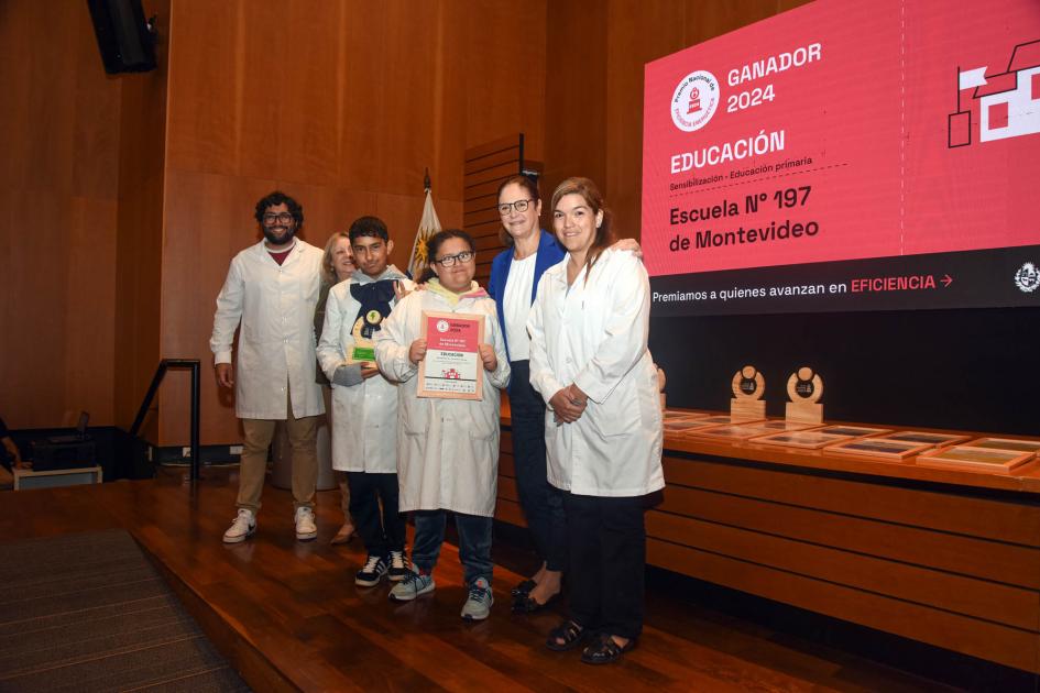 Ganador: Escuela n.° 197 para personas sordas y con alteraciones de lenguaje Ganadores (niños y adultos) sostienen un diploma junto a autoridad