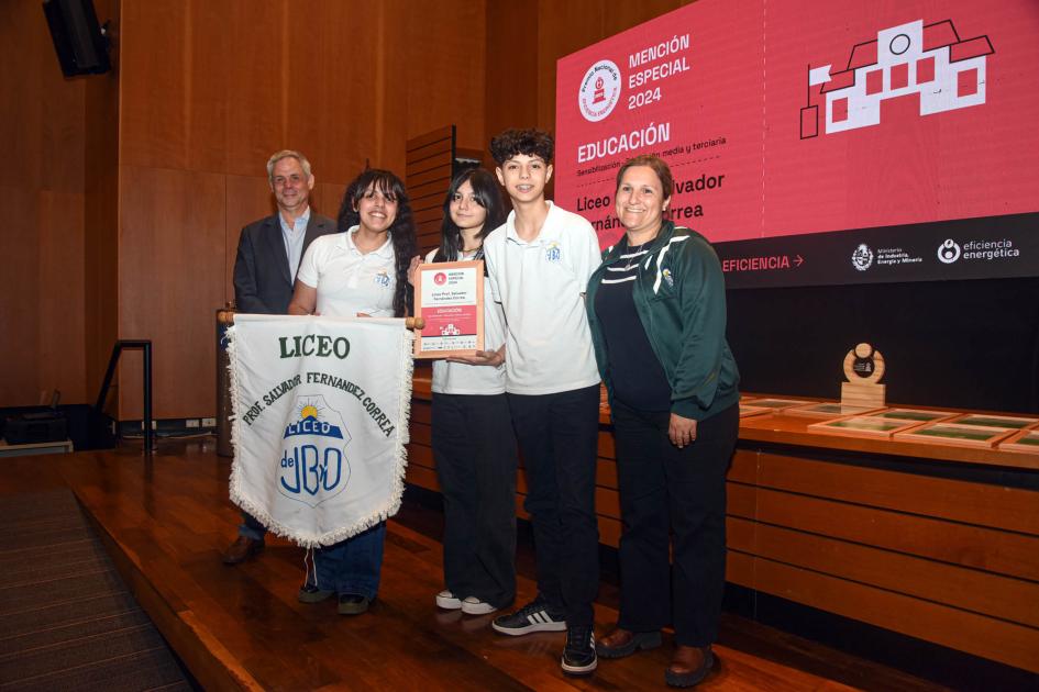 Mención especial: Liceo Prof. Salvador Fernández Correa de José Batlle y Ordóñez (Lavalleja) Ganadores sostienen un diploma y una bandera de su liceo junto a autoridad