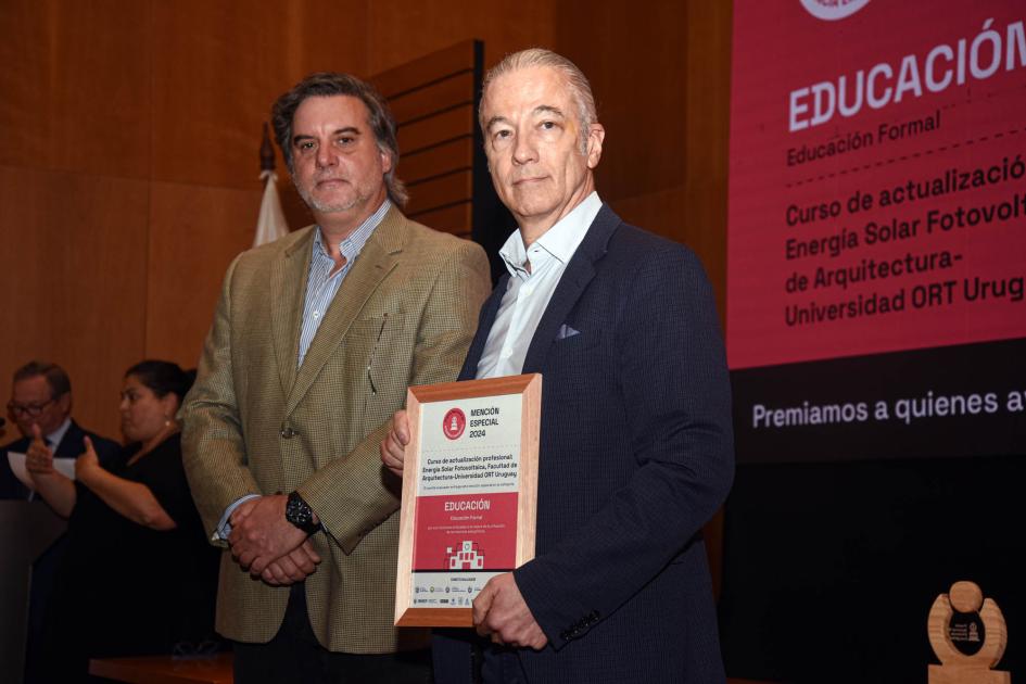 Mención especial: Curso de actualización profesional de la Facultad de Arquitectura de la ORT Ganador sostiene un diploma junto a autoridad