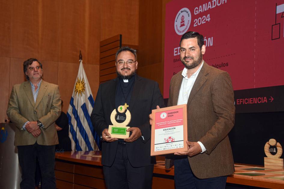 Ganador: Especialización en vehículos híbridos y eléctricos de Talleres Don Bosco Ganadores sostienen un premio y un diploma junto a autoridad