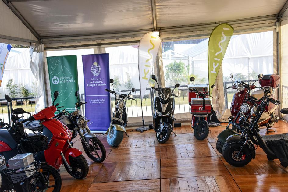 Se ven motos eléctricas, un banner del MIEM y un banner de Eficiencia Energética