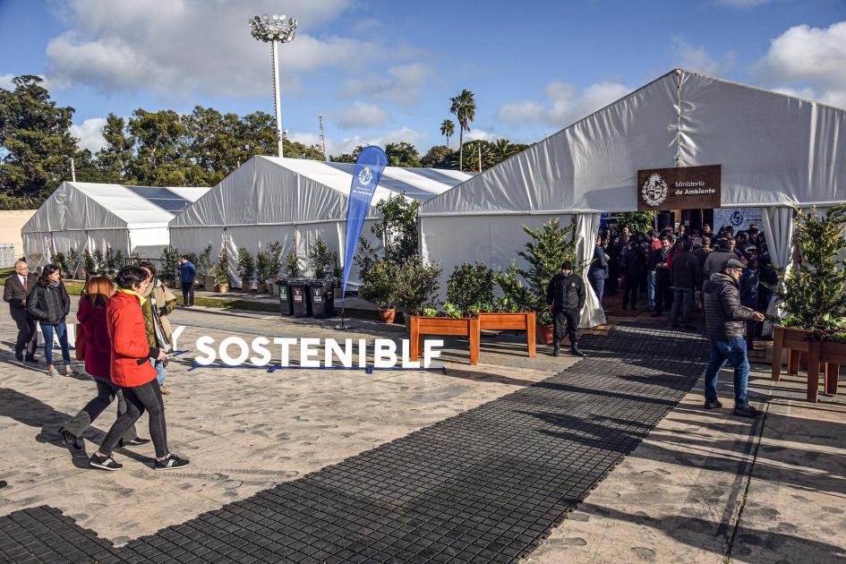 Espacio principal de la exposición Exterior de la carpe principal del evento; hay plantas y un cartel del Ministerio de Ambiente