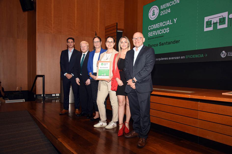 Mención: Banco Santander Ganadores sostienen un premio y un diploma junto a autoridad