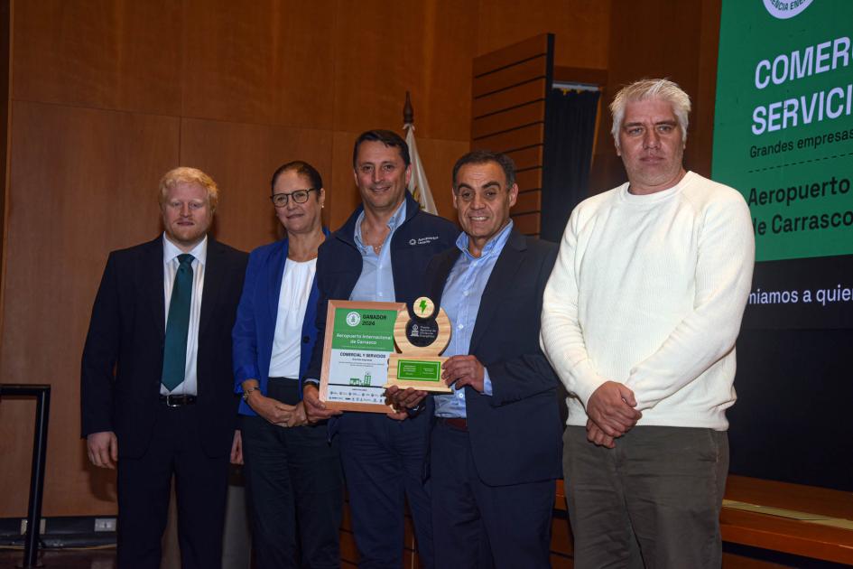 Ganador: Aeropuerto de Carrasco Ganadores sostienen un premio y un diploma junto a autoridad