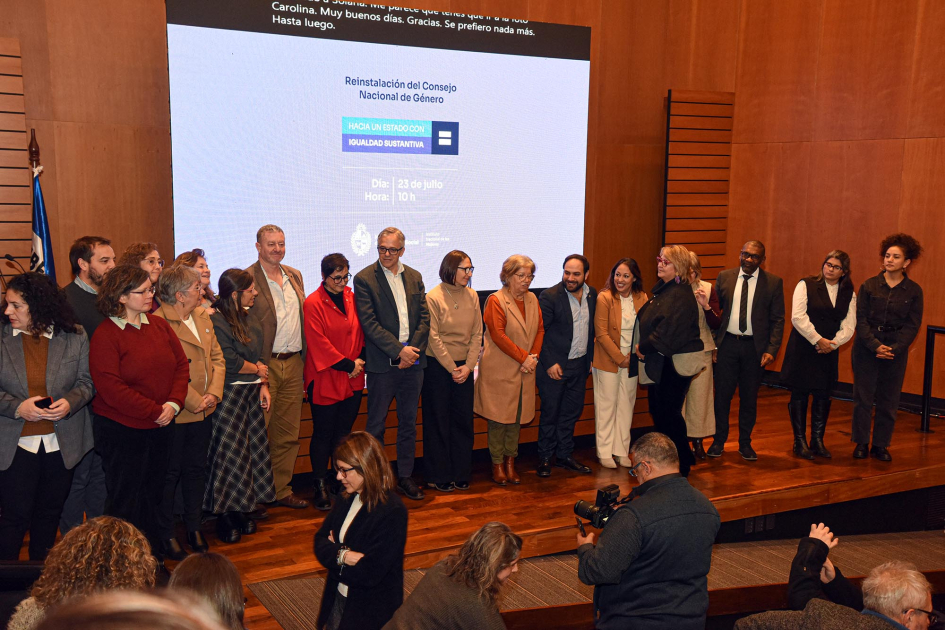 Autoridades participaron de la reinstalación del Consejo Nacional de Género Autoridades aplauden de pie; arriba, pantalla