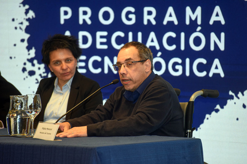 Ministro de Turismo, Pablo Menoni Menoni habla junto a Marazzano; detrás, pantalla