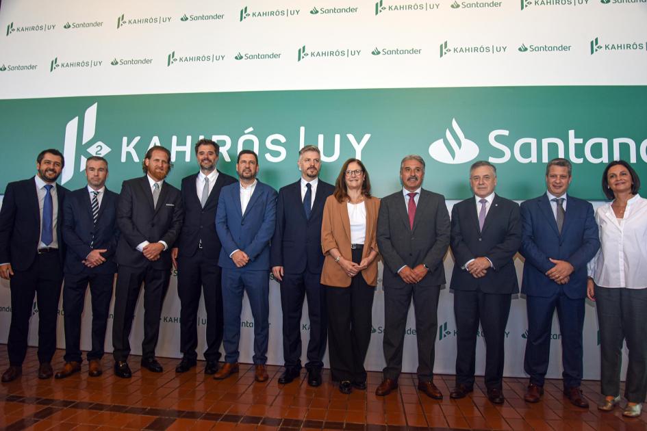 Autoridades e integrantes del proyecto Autoridades y miembros del emprendimiento, de pie; detrás, banner con logos de Santander y Kahirós