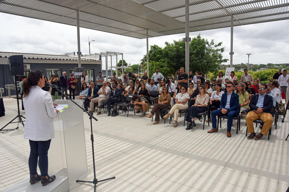Cardona habla, de espaldas; frente a ella, público
