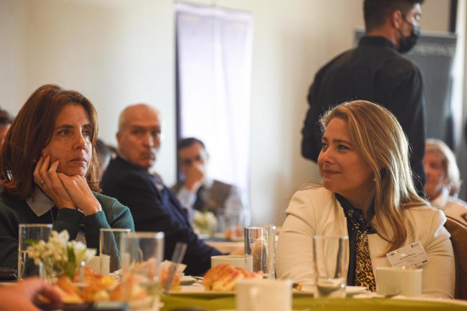 Mesa en la que participó Susana Pecoy, que sonríe junto a otra mujer; detrás se ven otras personas