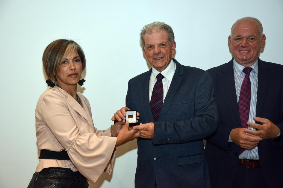 Trabajador recibe un premio, junto a autoridades