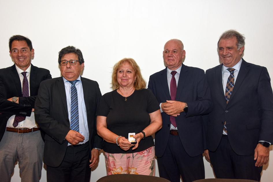 Trabajadora recibe un premio, junto a autoridades