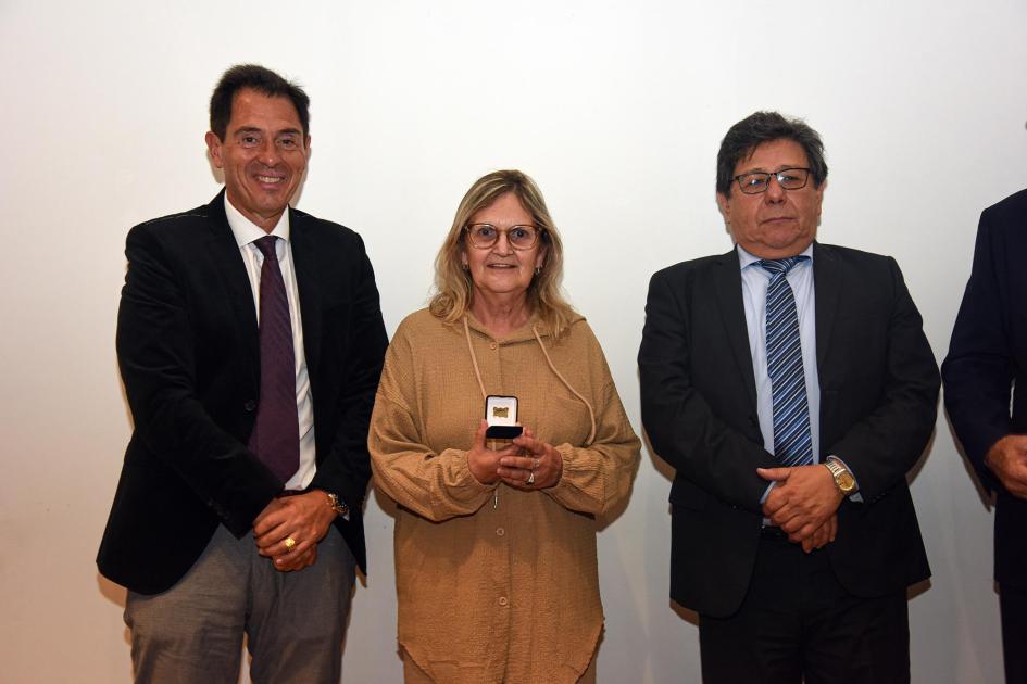 Trabajadora recibe un premio, junto a autoridades