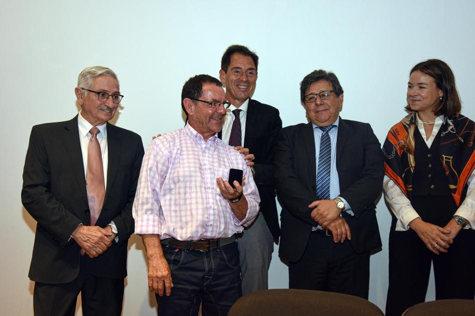 Trabajador recibe un premio, junto a autoridades