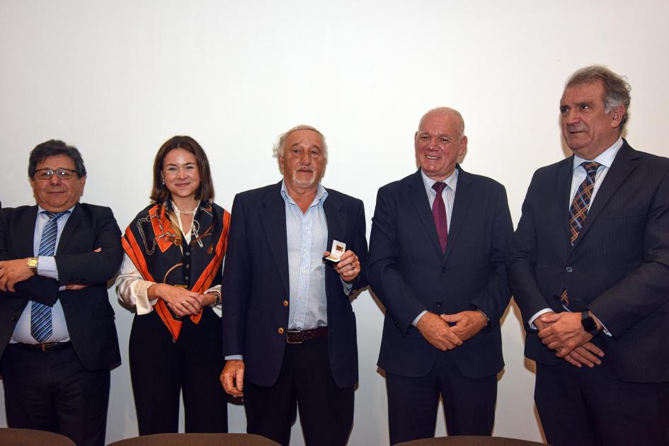 Trabajador recibe un premio, junto a autoridades