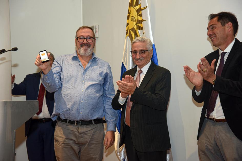 Trabajador recibe un premio, junto a autoridades
