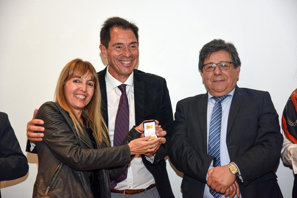 Trabajadora recibe un premio, junto a autoridades