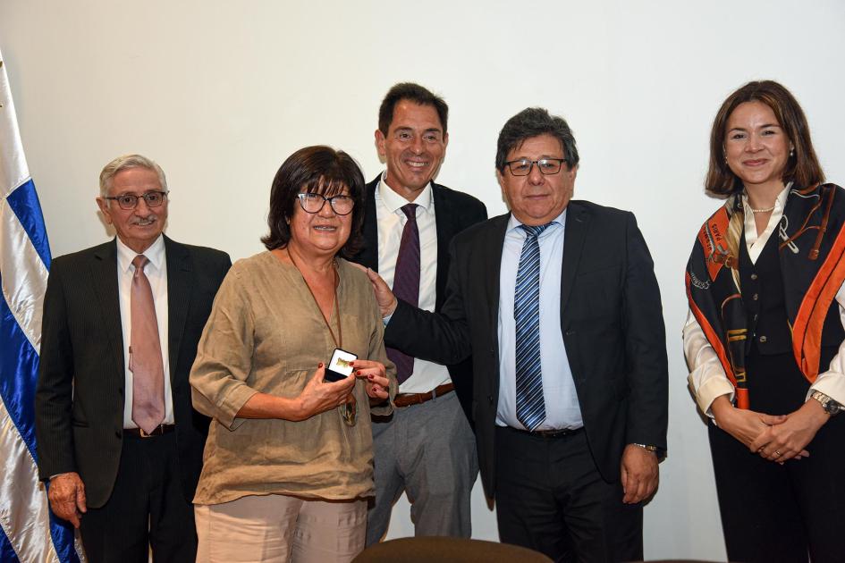 Trabajadora recibe un premio, junto a autoridades