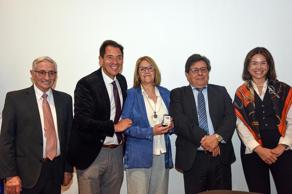 Trabajadora recibe un premio, junto a autoridades