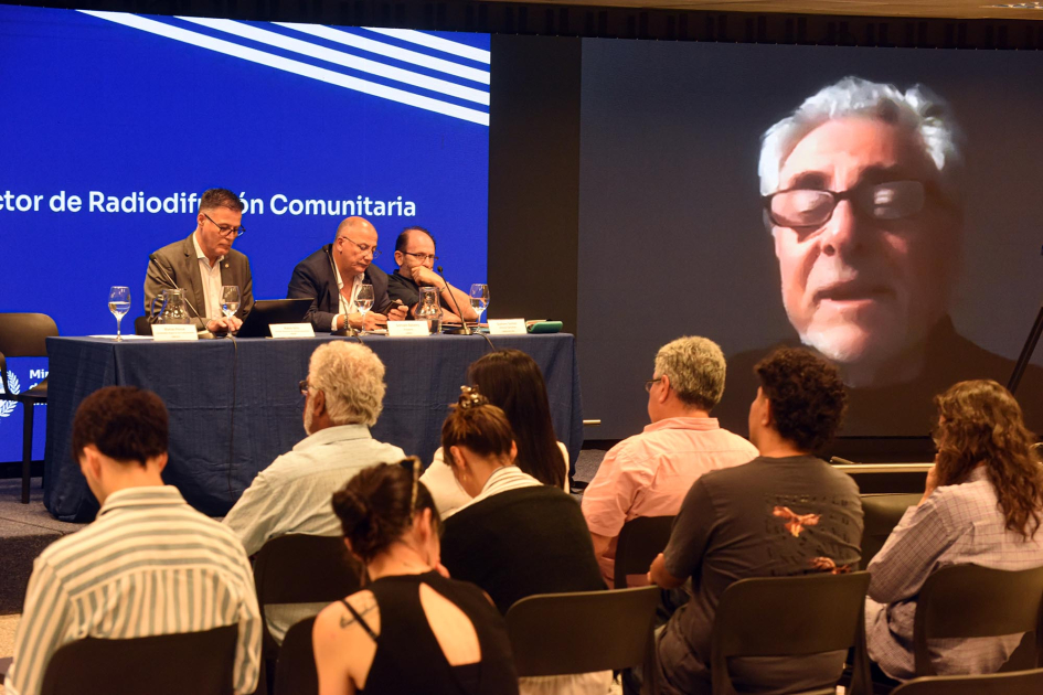 Pablo Siris, Gonzalo Balseiro y Gustavo Gómez. Al lado, en pantalla, Gabriel Kaplún