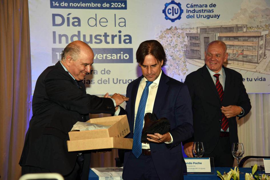 El presidente Luis Lacalle Pou participó de la ceremonia Pache entrega un regalo a Lacalle Pou; detrás, Verri sonríe