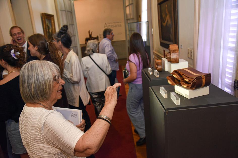 La exhibición puede visitarse hasta marzo de 2025 Una mujer observa una artesanía; detrás, otras personas