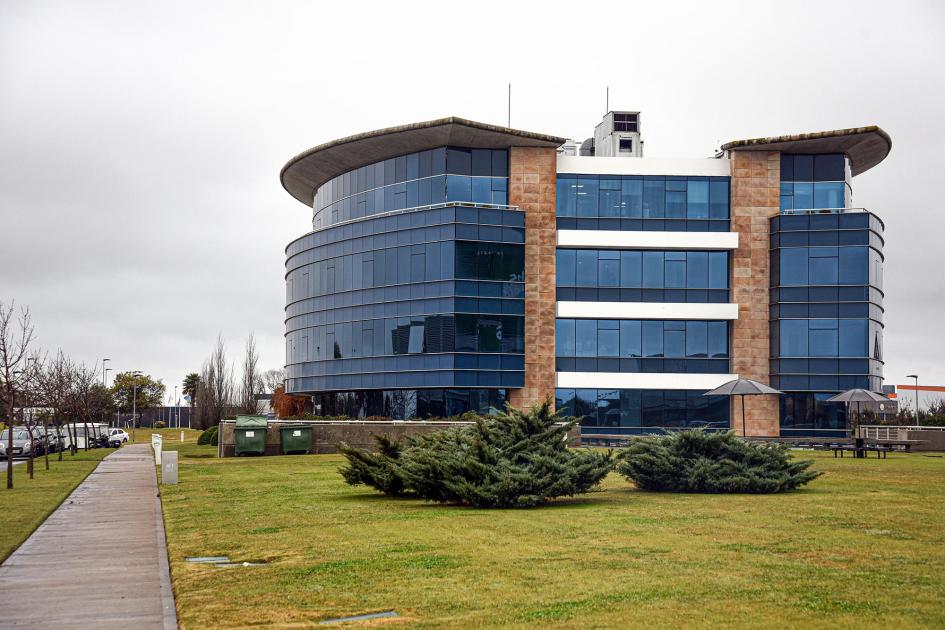 Parque de las Ciencias Fachada de un moderno edificio vidriado; hay pasto alrededor