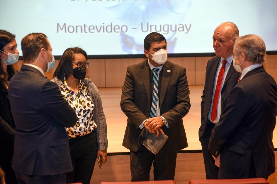 Miembros de diez países intercambian sobre los contenidos del IPPALC Integrantes de las delegaciones dialogan; detrás se ve el escenario, con una gran pantalla blanca