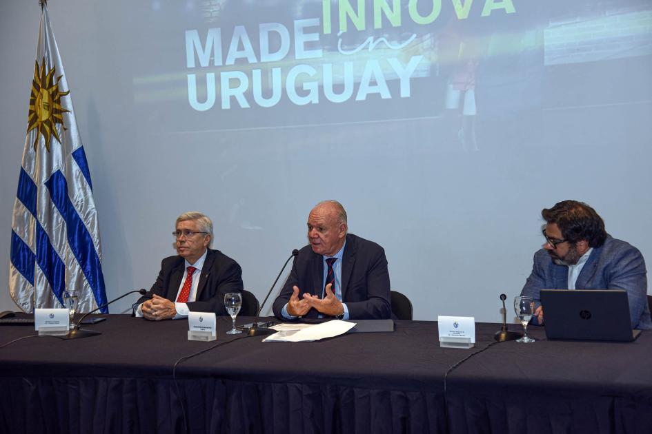 Mesa de autoridades; al lado, una bandera uruguaya