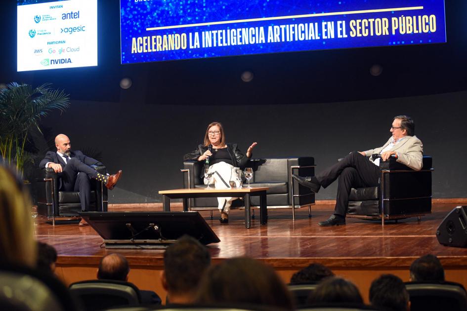 Primer panel de la actividad Suburú, Paguas y Perea, sentados en sillones sobre el escenario