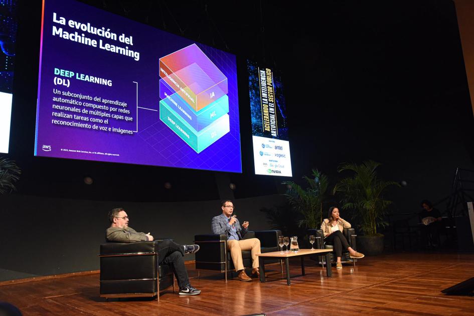 Segundo panel de la actividad Jolo, Castillo y Silva, sentados en sillones; arriba, gran pantalla